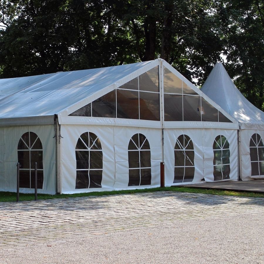 Proveedor de mobiliario para eventos en Madrid preparando mesas, sillas y una carpa abierta